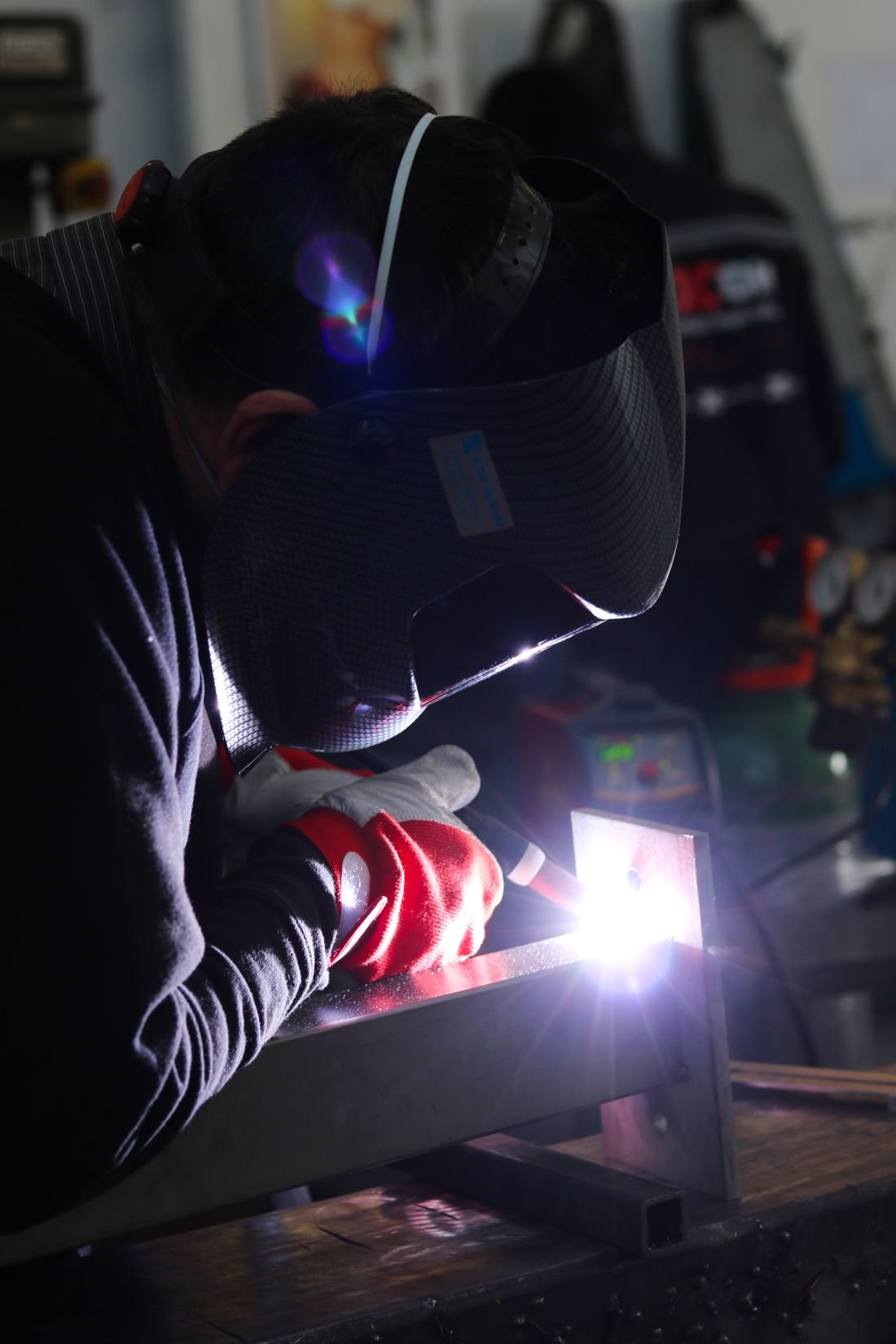 Welder using a TIG torch on a steel frame, bright arc